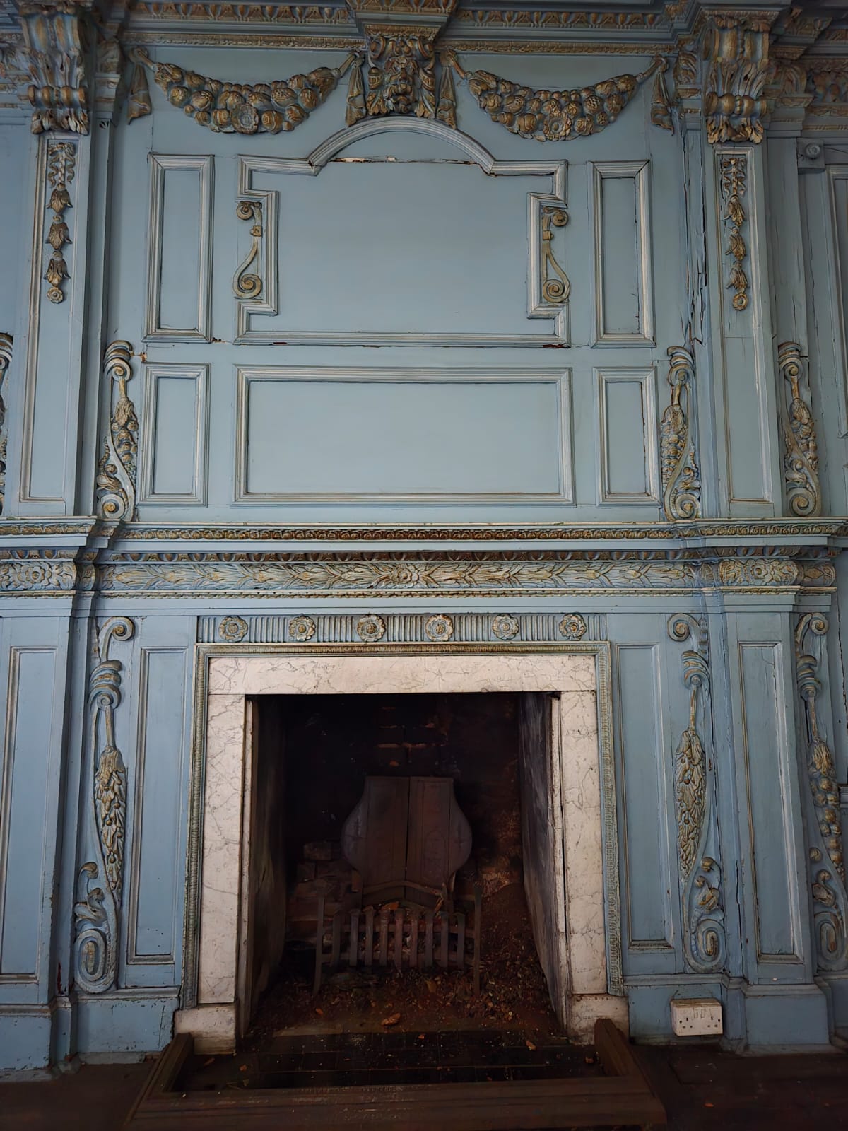 Ornate blue panelled room with marble fireplace